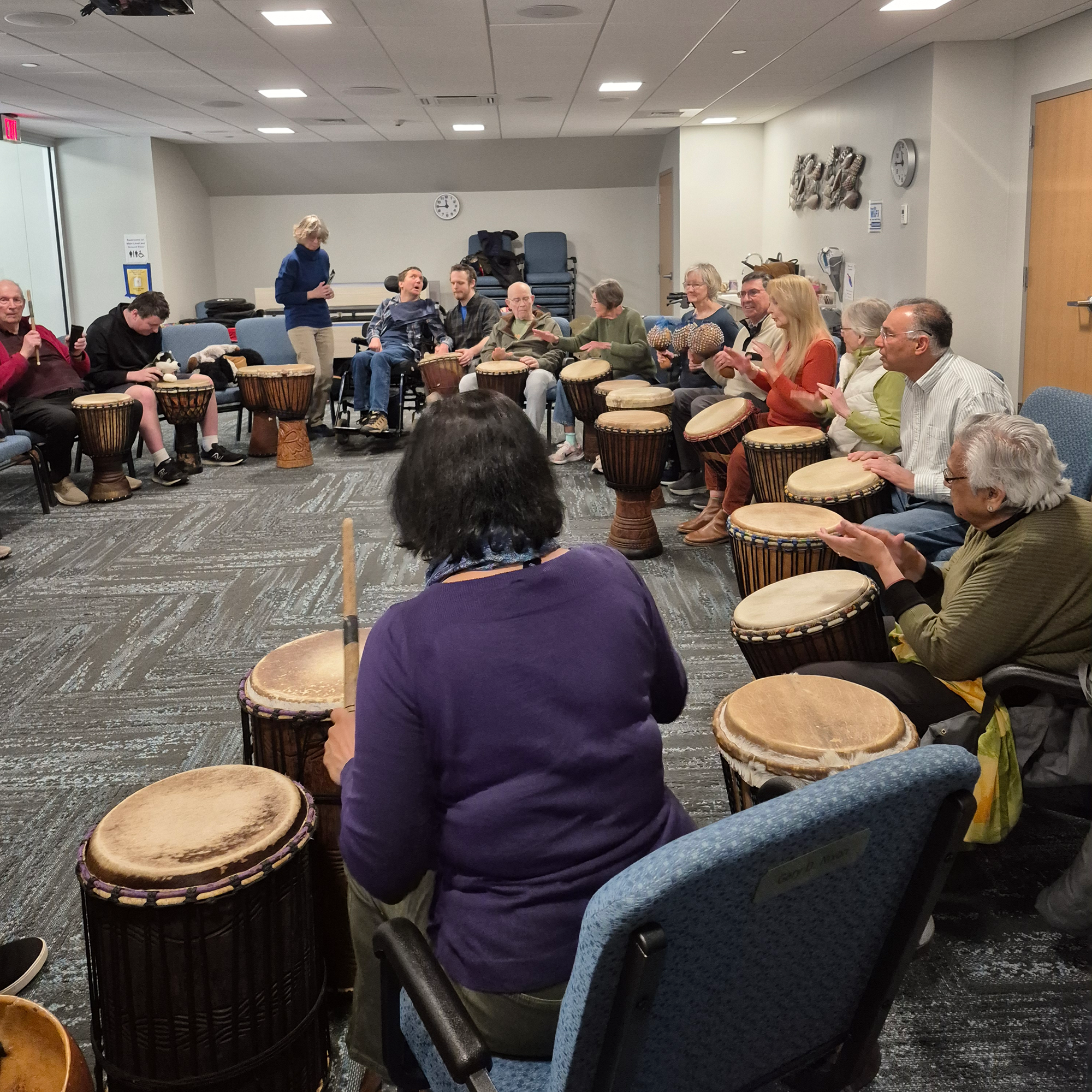 Close up of patrons playing drums in the Meeting Room.