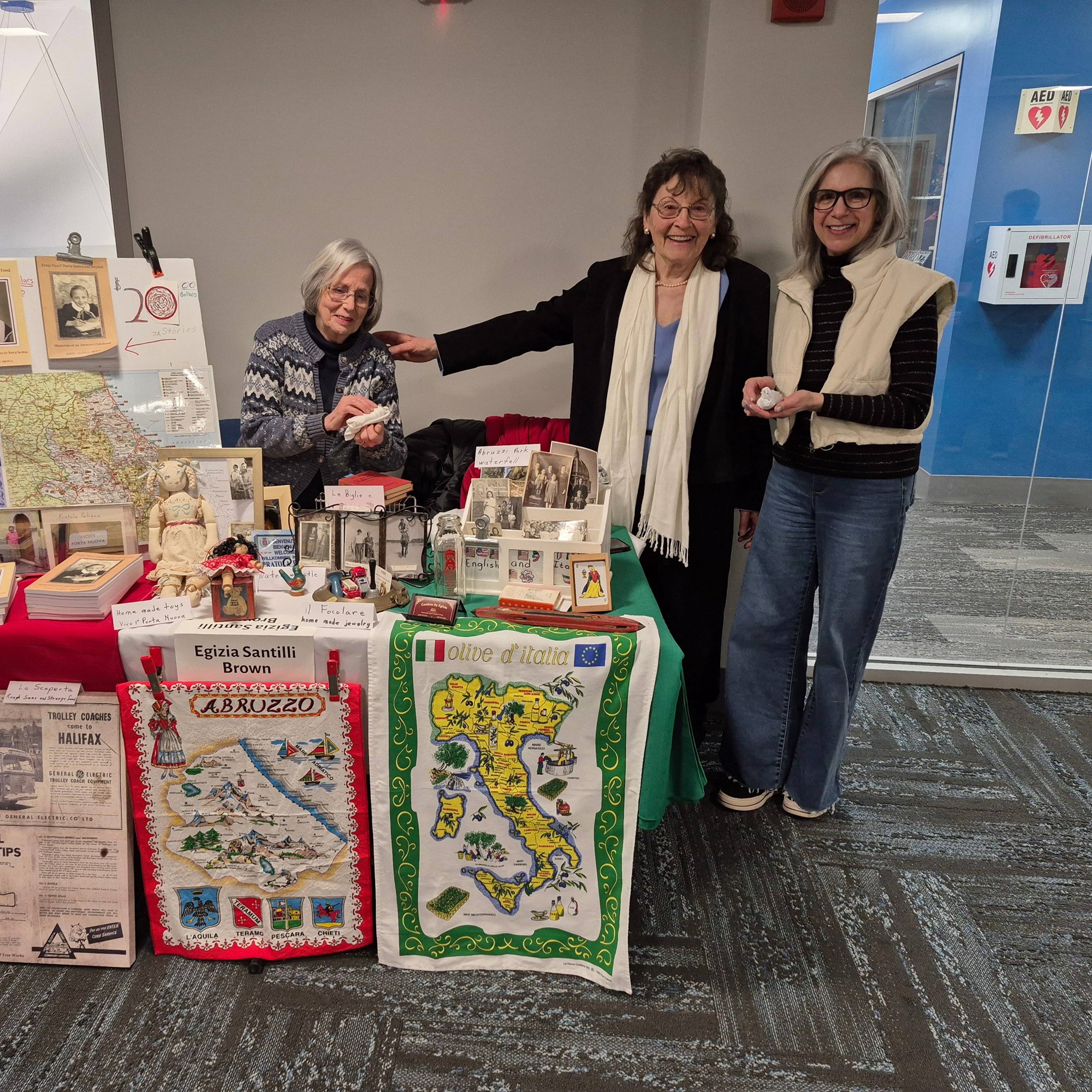 Egizia Brown posing with friends at her booth on the Mezzanine floor of the library.