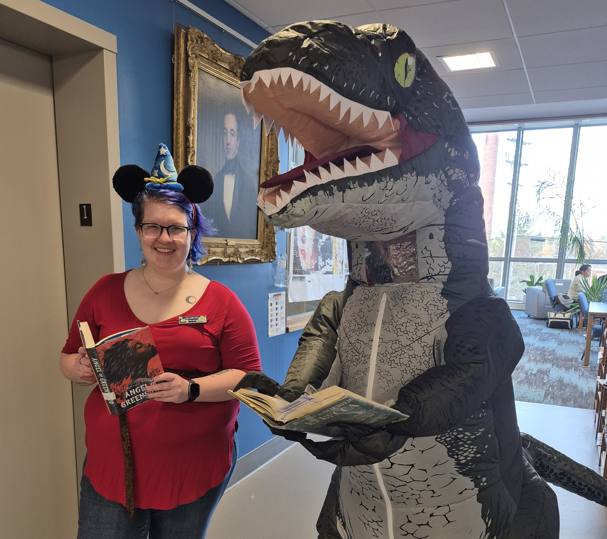 Librarians Chandra and Shelby dressed as a Disney adult and dinosaur