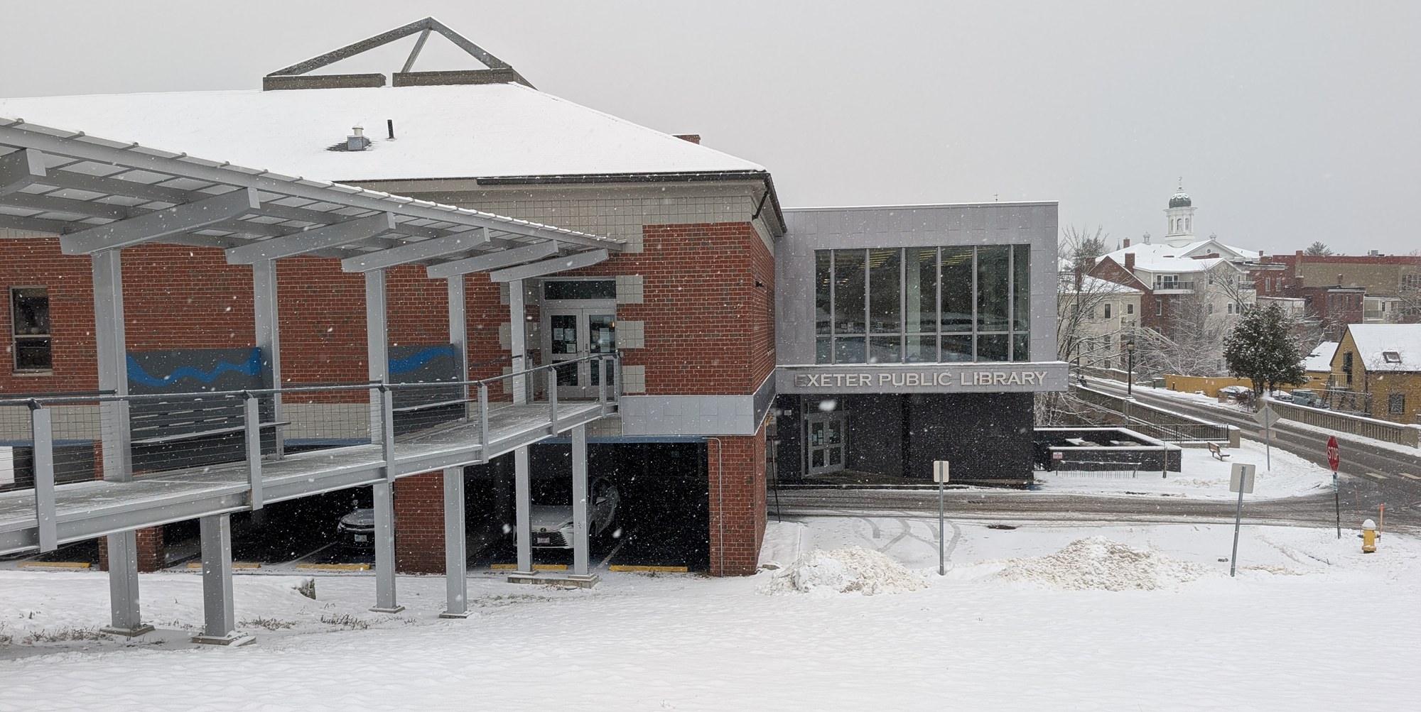 A view of the outside of the library as snow falls.