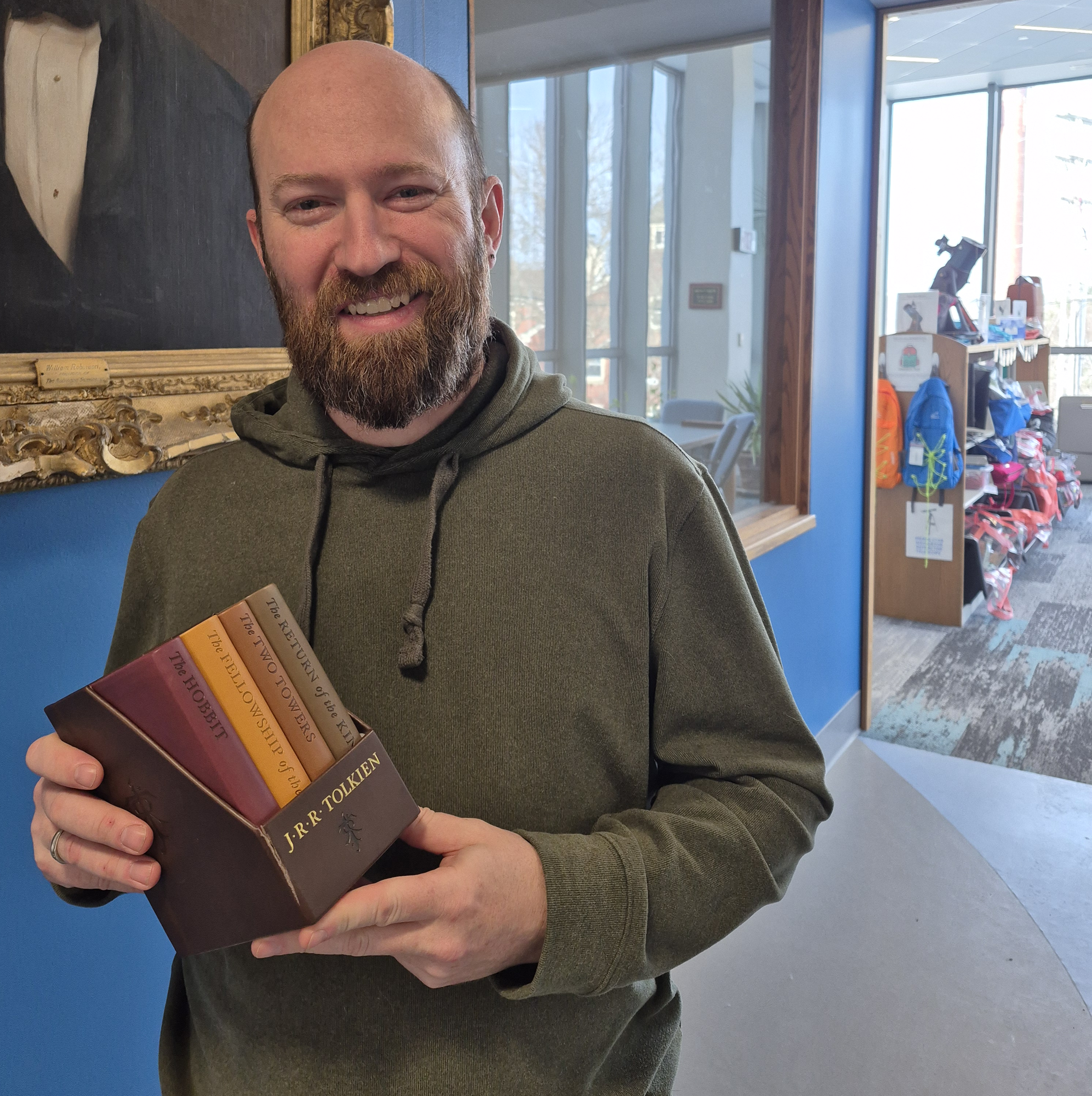 The winner holding his new set of leather bound copies of The Hobbit and The Lord of the Rings.