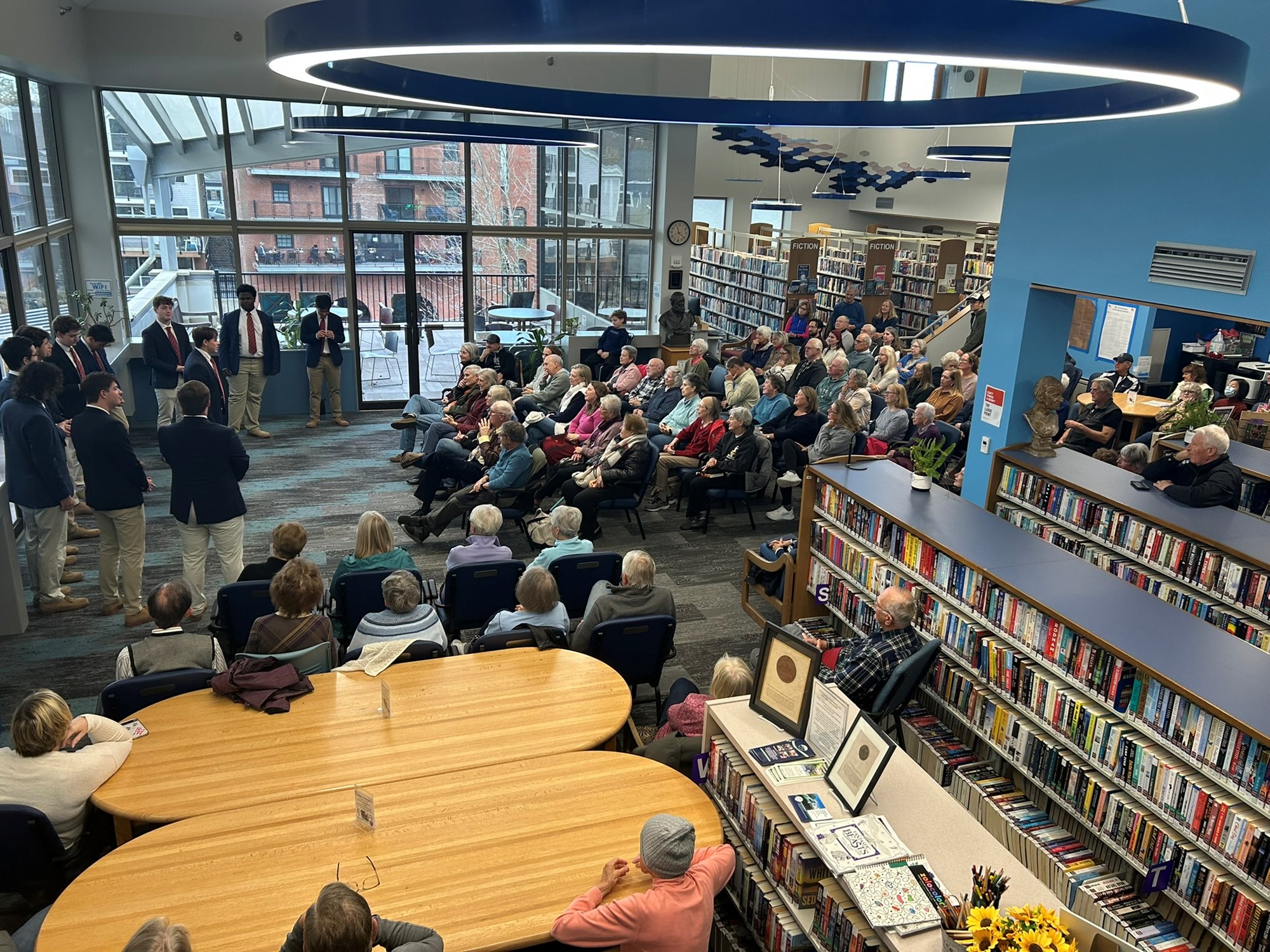 Colgate Thirteen performing in the main seating area of the library.