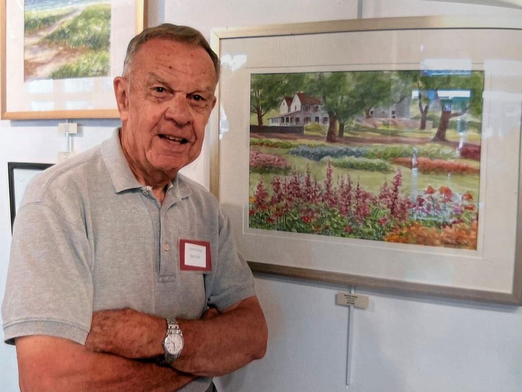 October artist Bill Childs posing in front of one of his paintings.