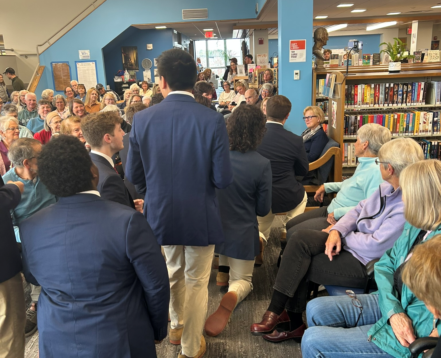 Colgate Thirteen performing in the main seating area of the library.
