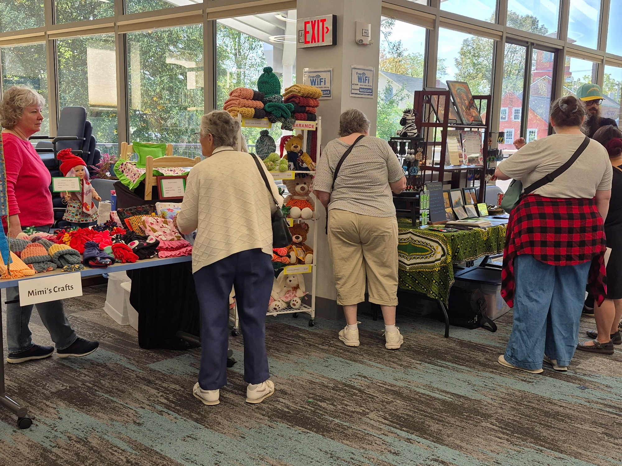 Visitors browsing crafter and artists' wares on the main floor of the library