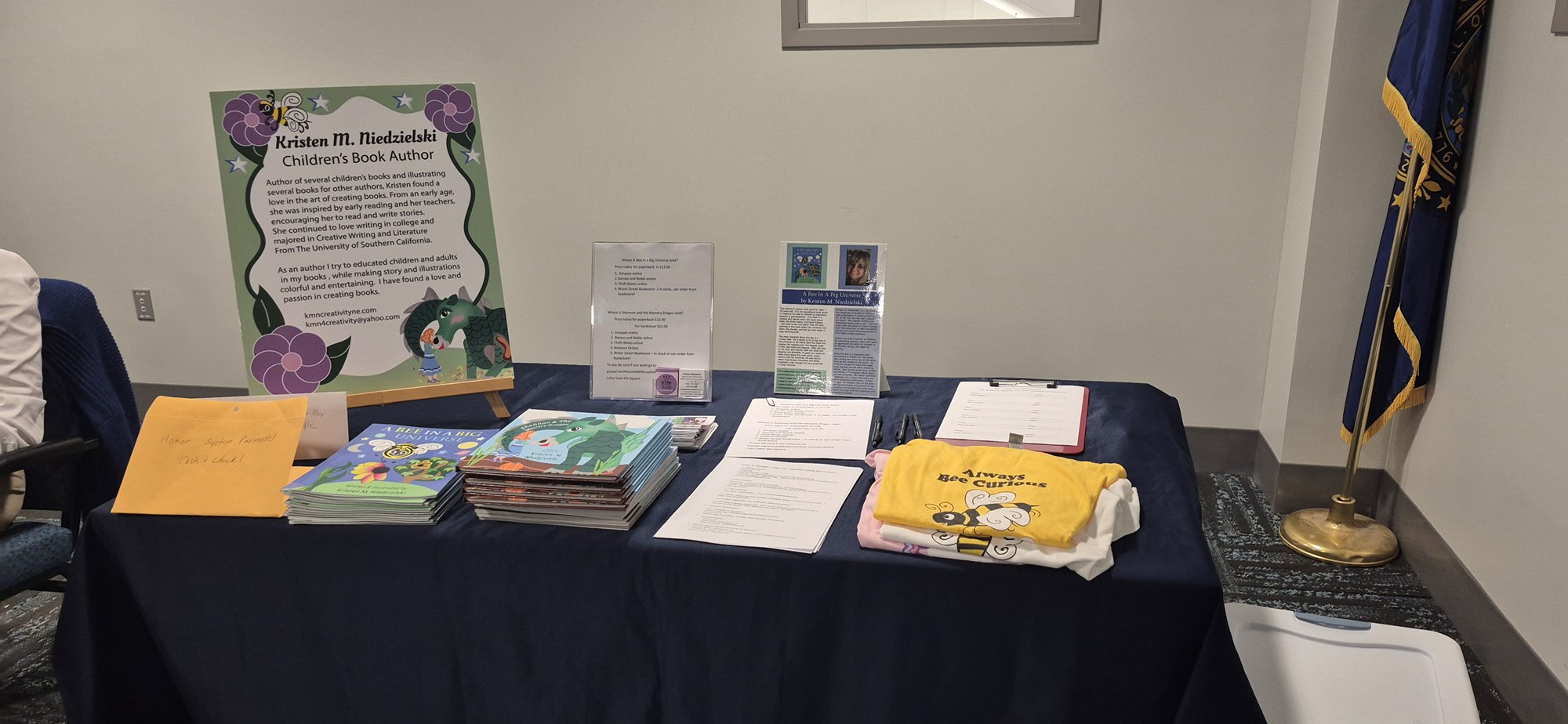 Niedzielski's books, merchandise, and other items on display in a table in the Meeting Room. 
