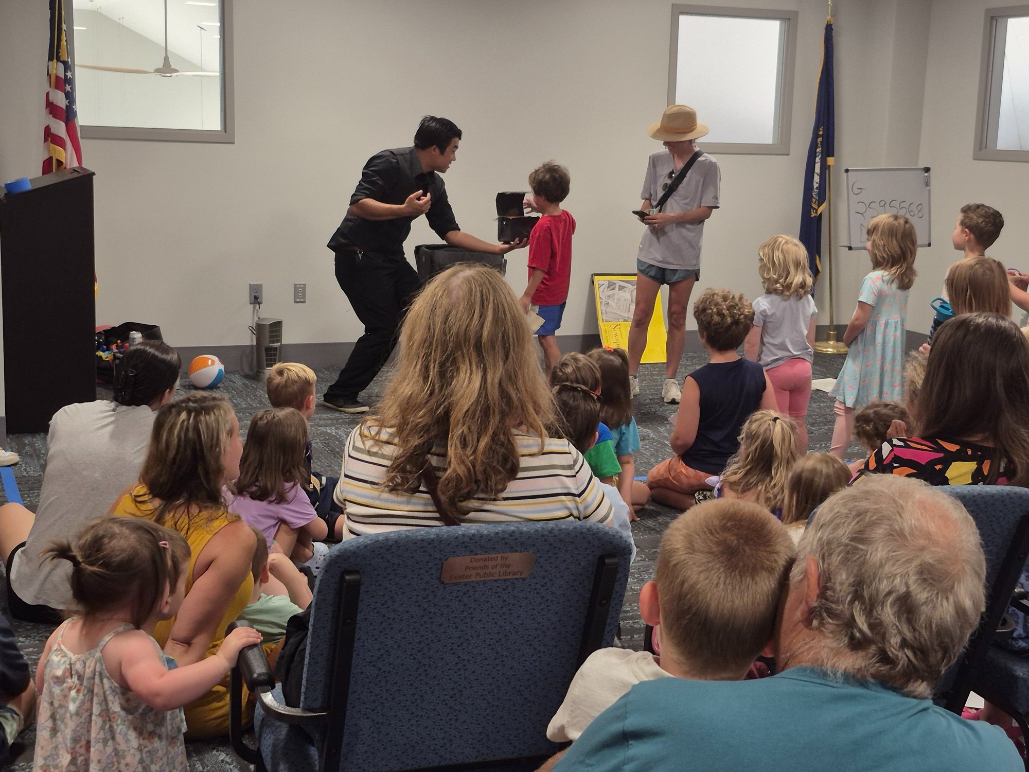 Norman Ng performing a magic trick in the Meeting Room of the library.