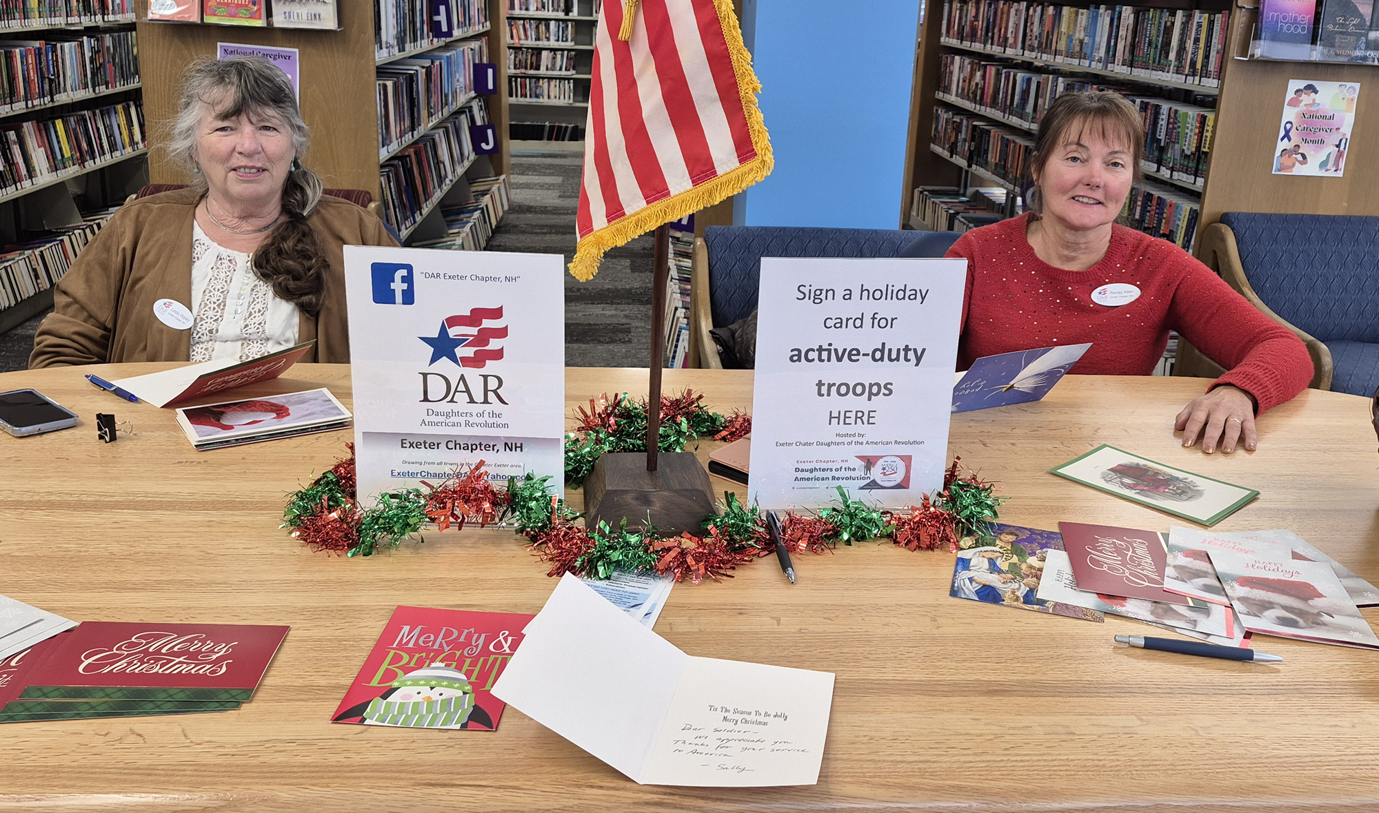 Members of DAR at their table with holiday cards to be signed for active-duty troops.