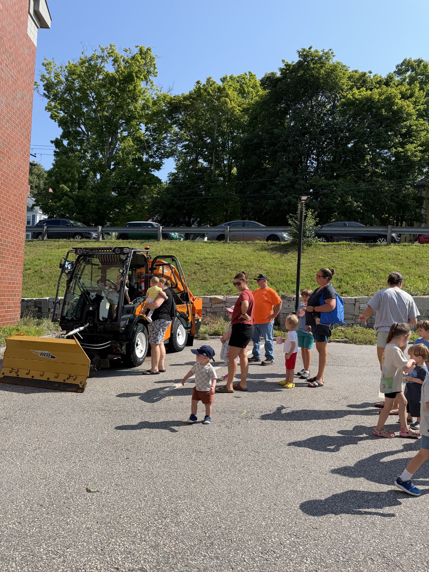 Patrons looking at a DPW vehicle in the library's parking lot during Touch-a-Truck.