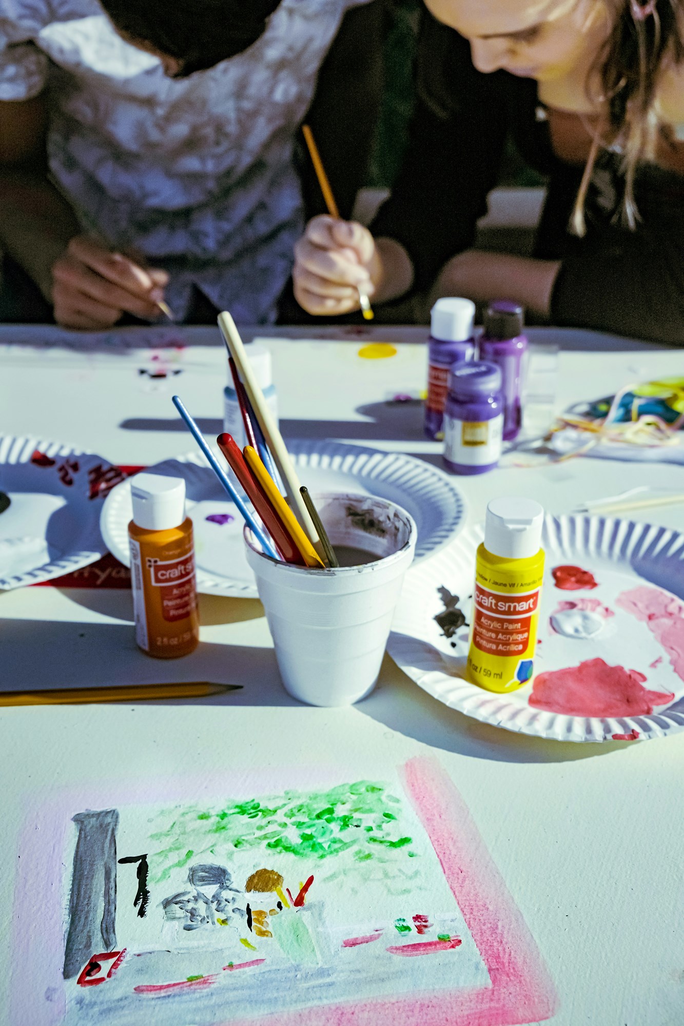Group painting activity with acrylic supplies outdoors