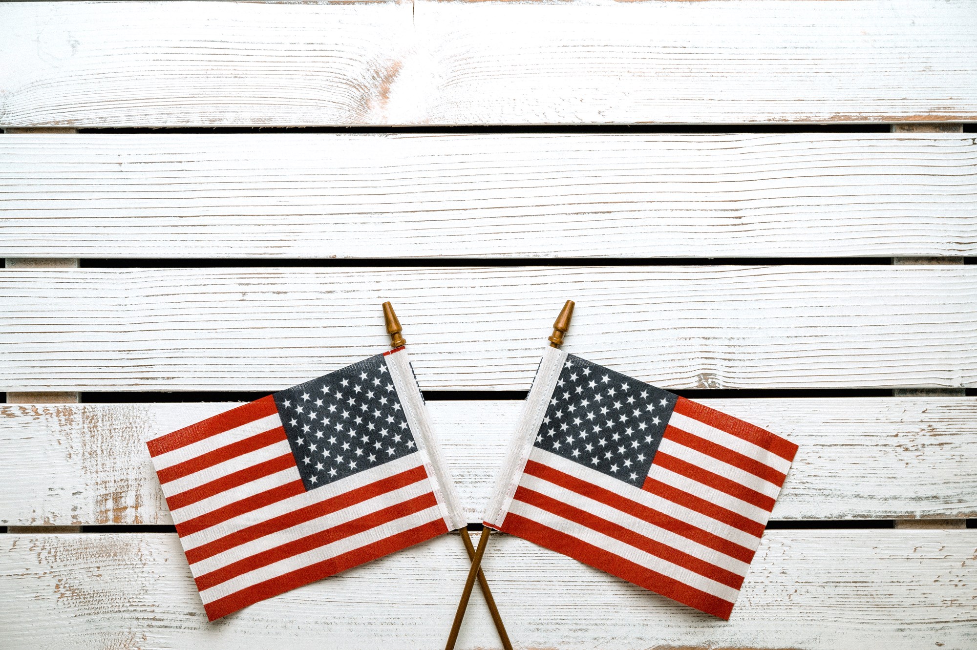 Two Small American Flags on White Wood Background