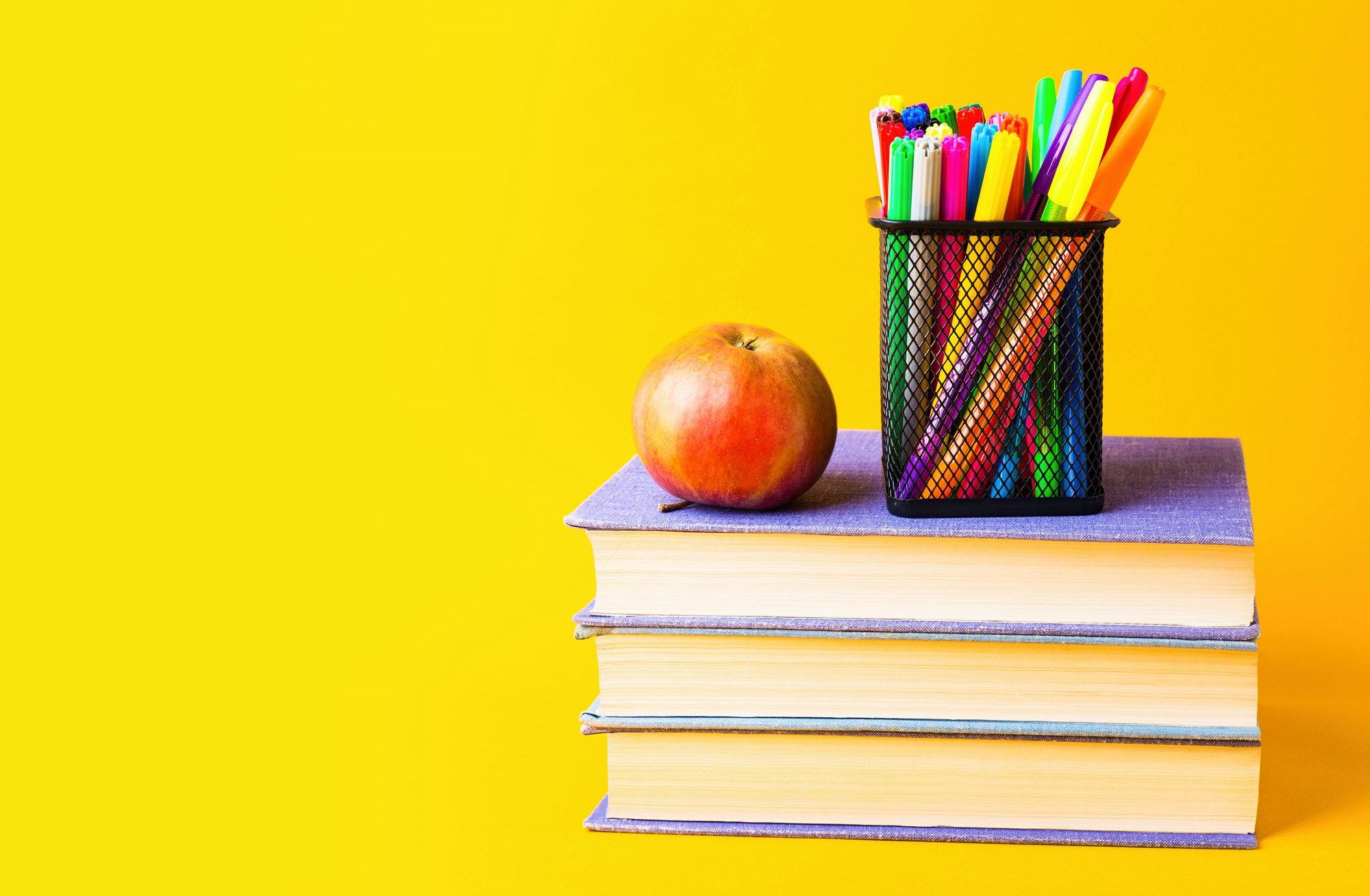 Pencils and Apple on Top of Books