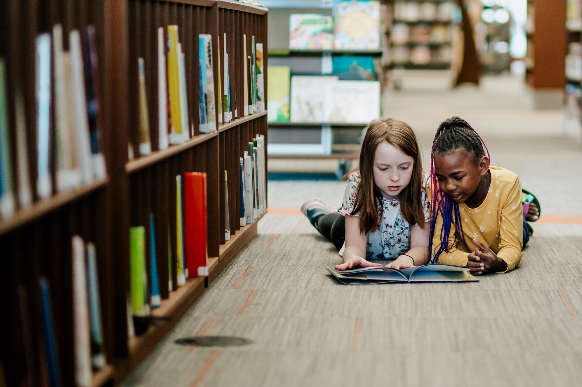 Two Girls Reading a Book in the Library