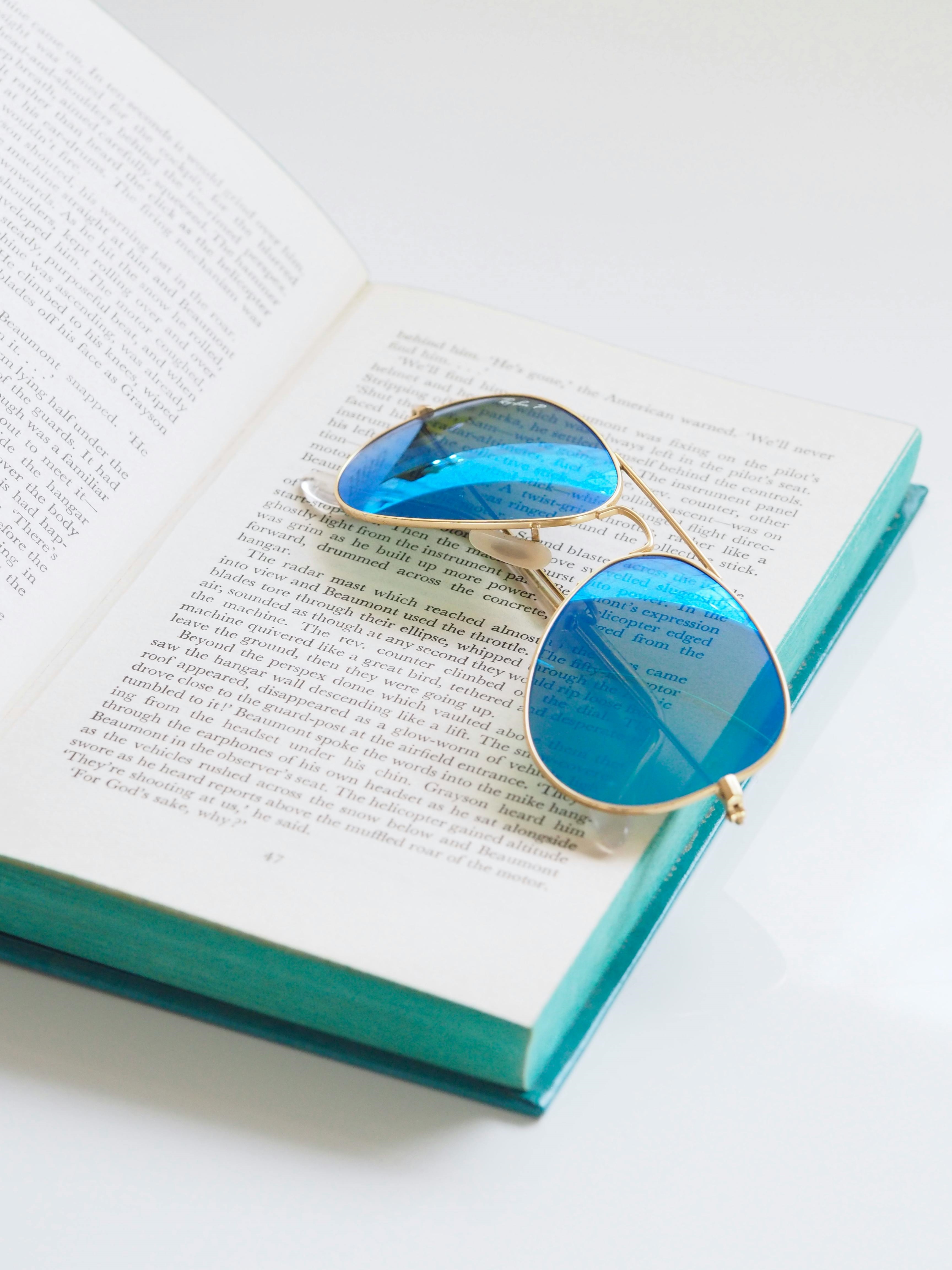 Close-up Photography of Book and Sunglasses