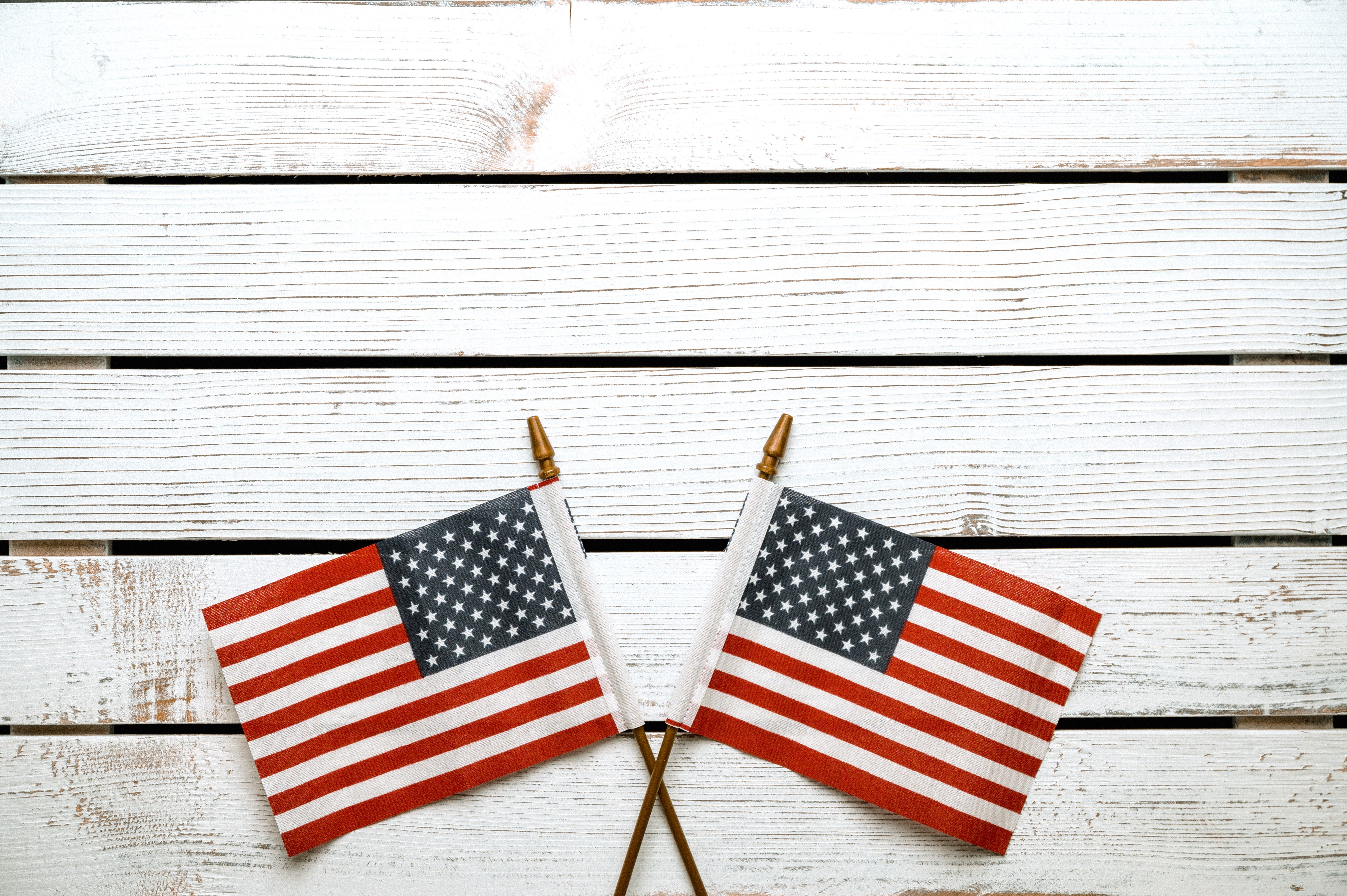 Two Small American Flags on White Wood Background