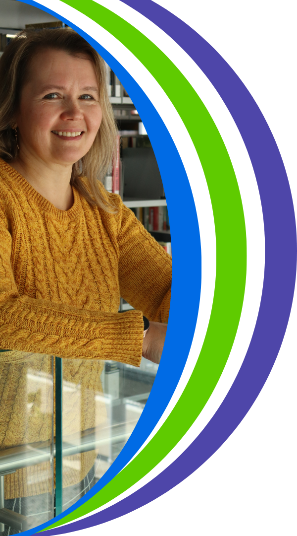Photo of Siiri smiling in front of book shelves. 