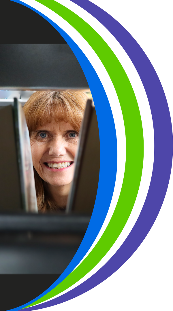 Photo of Elisa looking between a stack of books