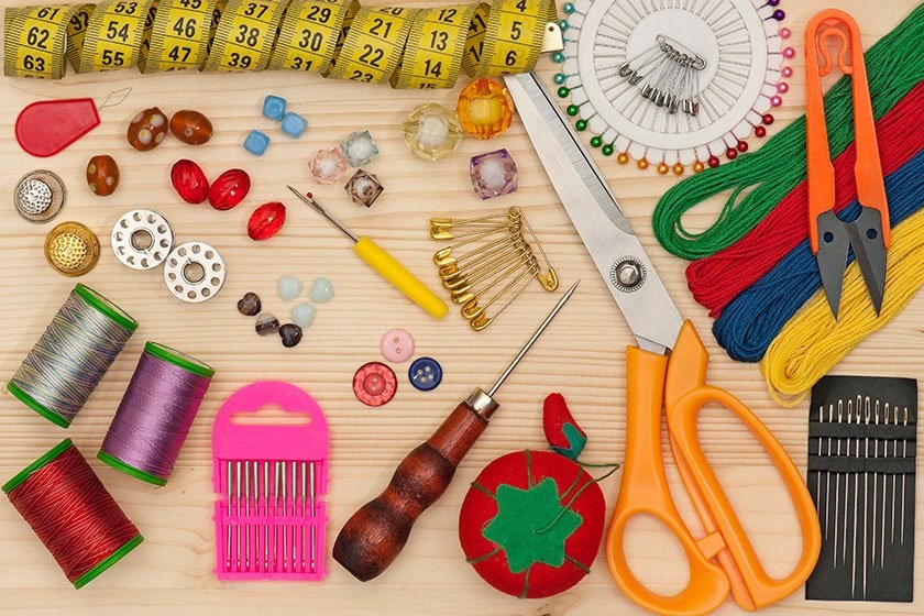 Sewing needles, spools of thread, pins, scissors, and other sewing tools