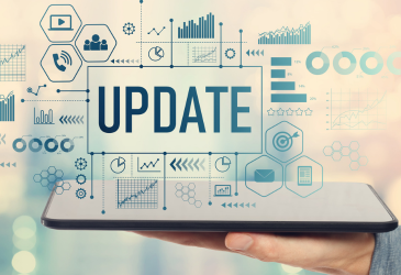 Man holding a tablet with update above it surrounded by computer icons.