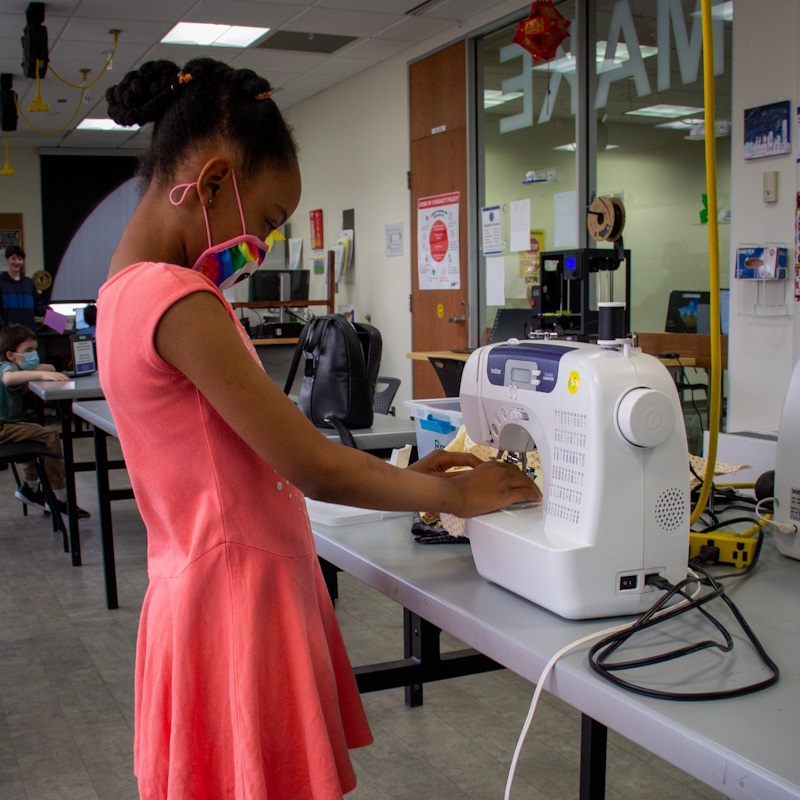 A child using a sewing machine in the makerspace.