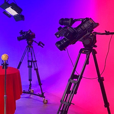 Studio 21c with two cameras, a microphone, and lights set up.
