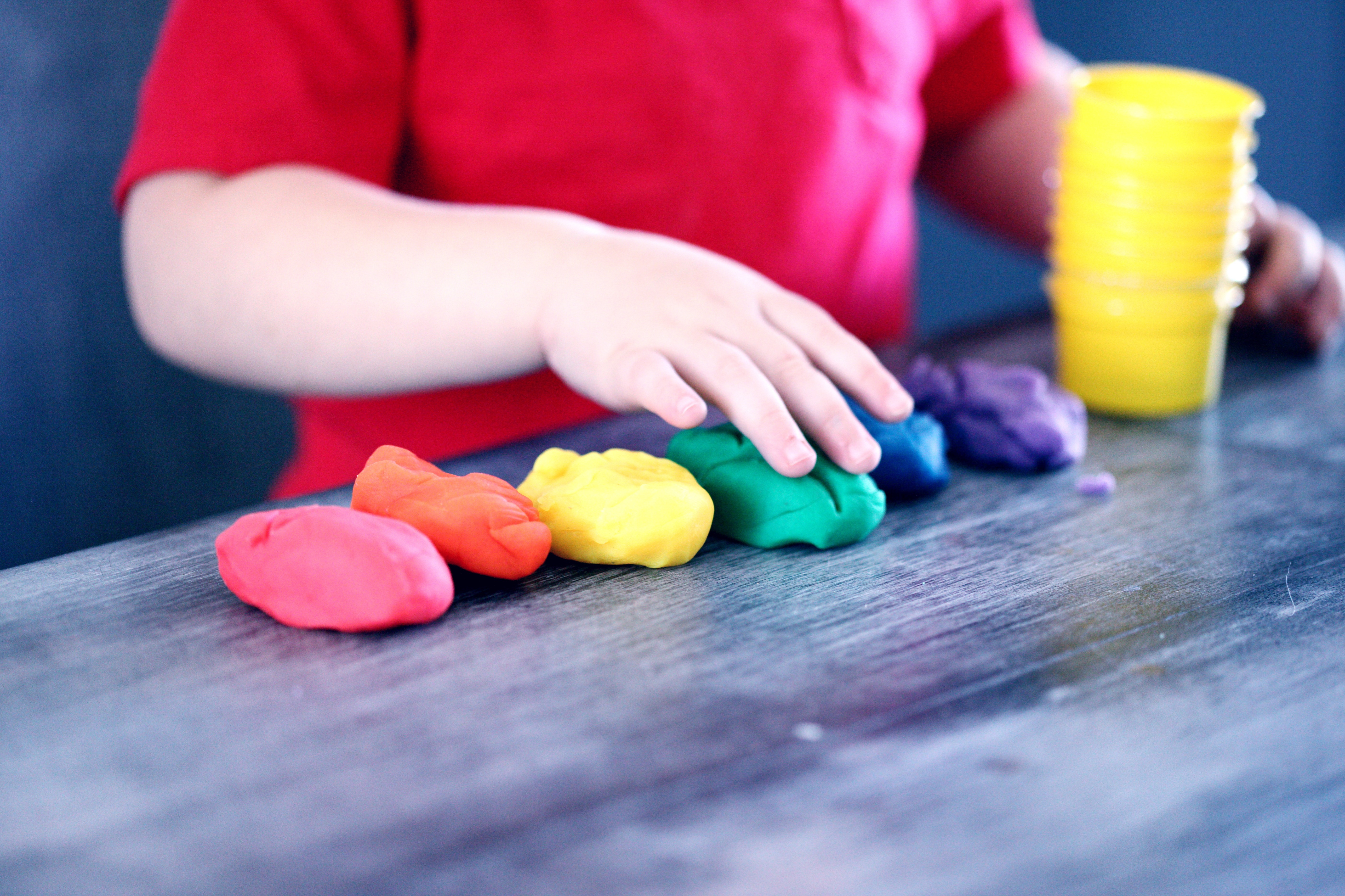 Child Playing with Rainbow Colored Play Dough