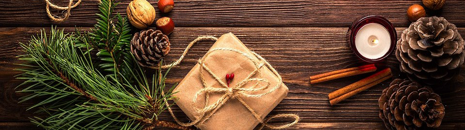 photo of pine bough, pine cones, candle, and wrapped present