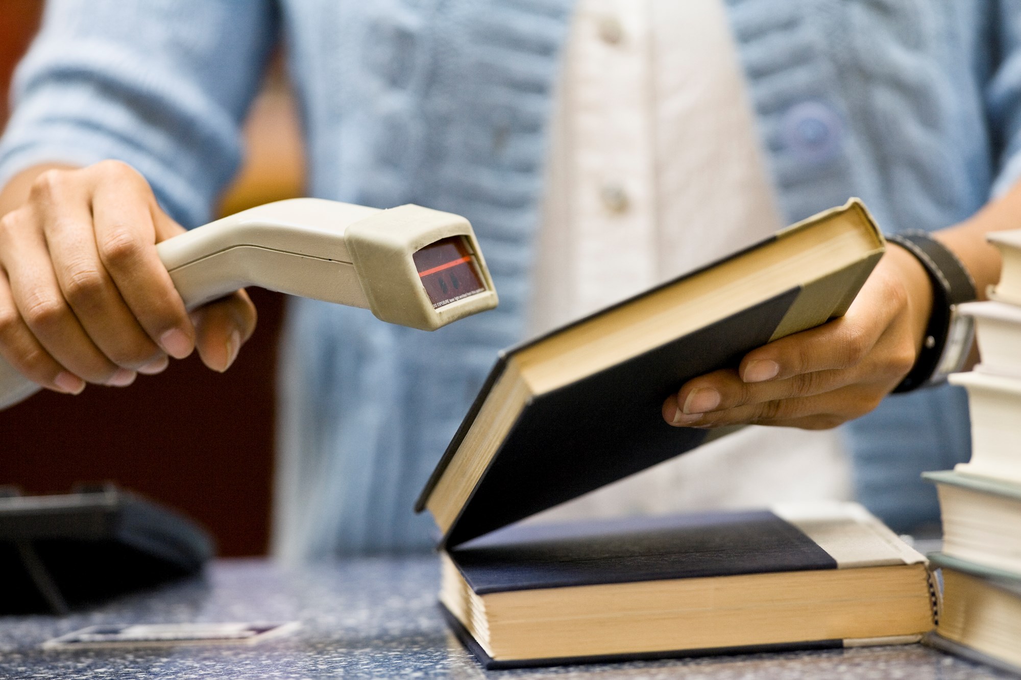 Woman Scanning a Book in Library