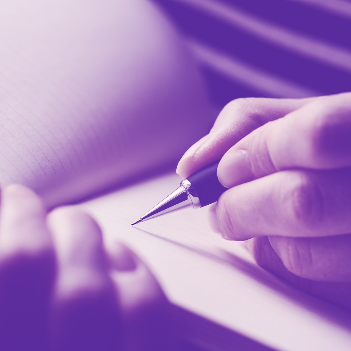 In all purple hues, hands hold a pen and write in a blank notebook.