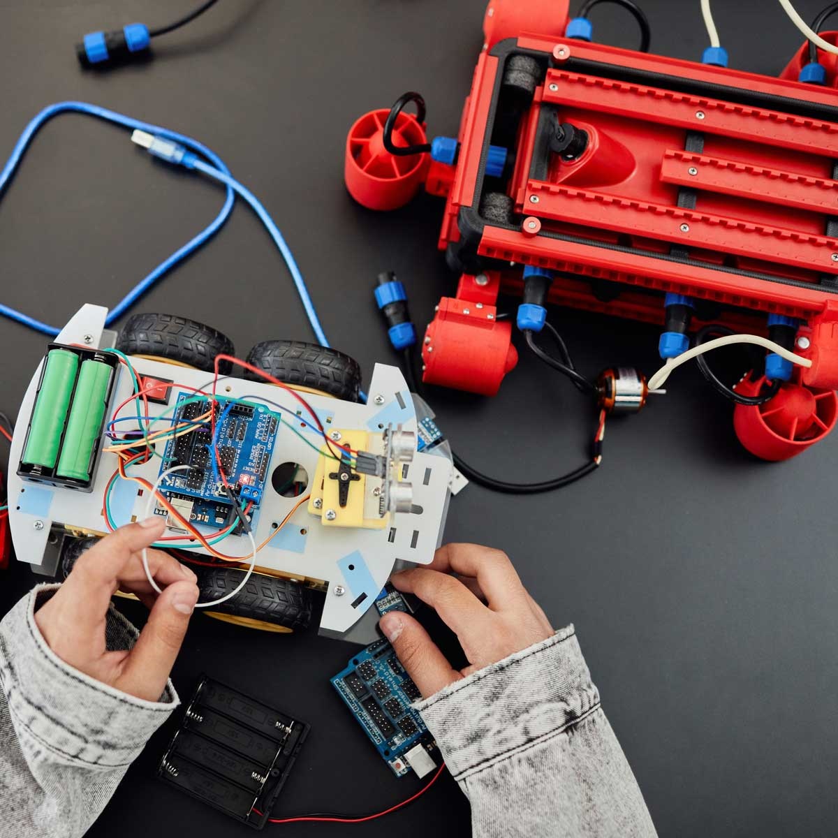 child-size hands playing with electronic components