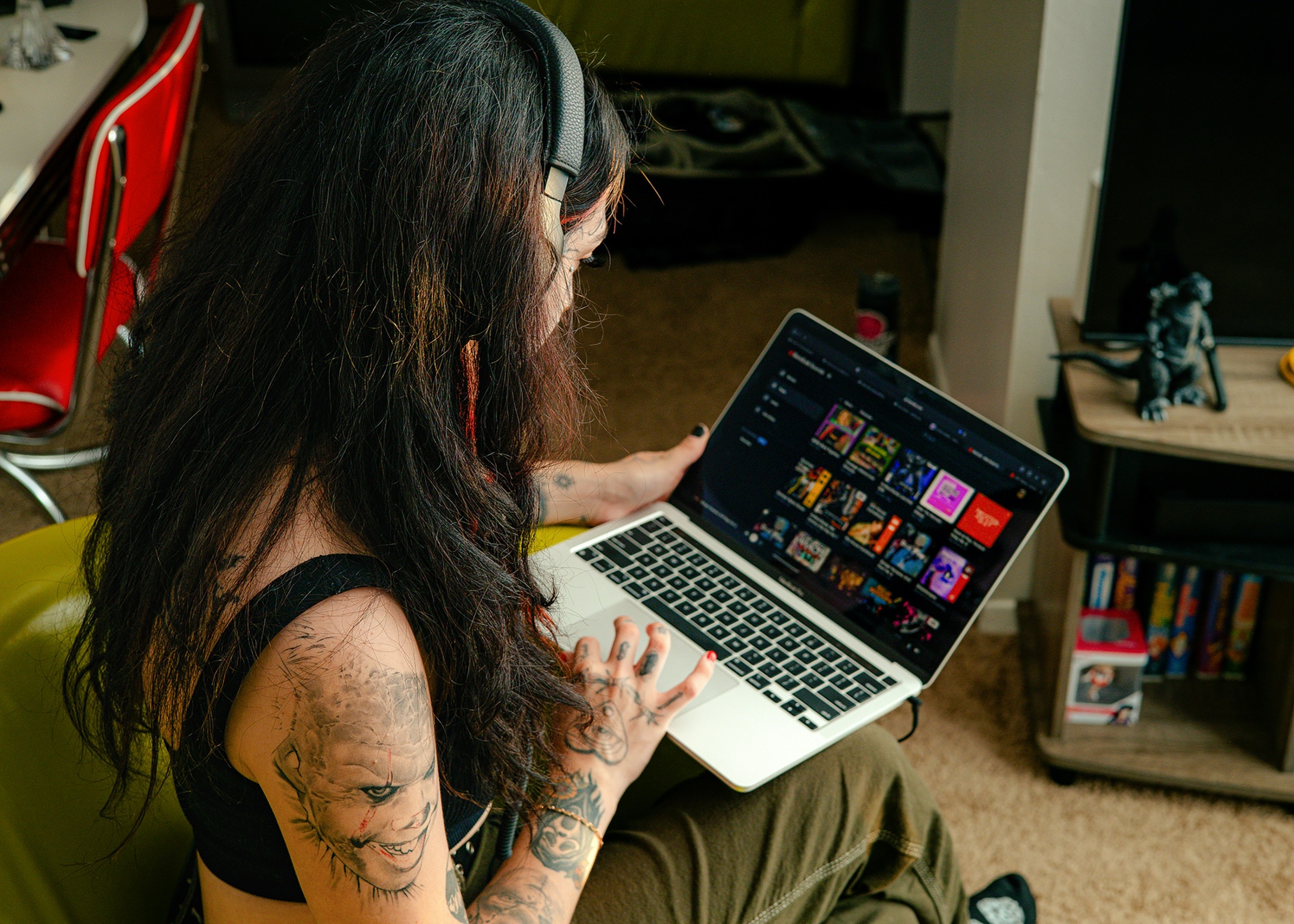 Image depicts a brunette woman using a laptop on her lap.