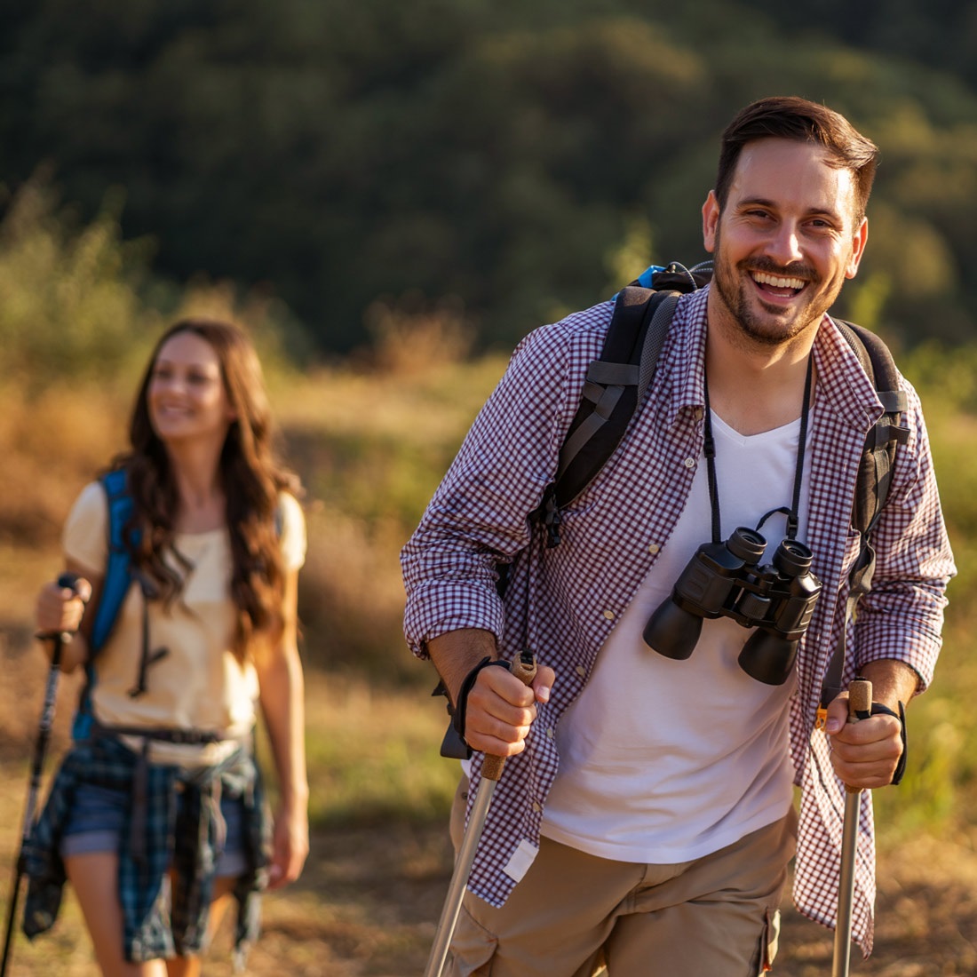 A man and a woman, out hiking and participating in geocaching.