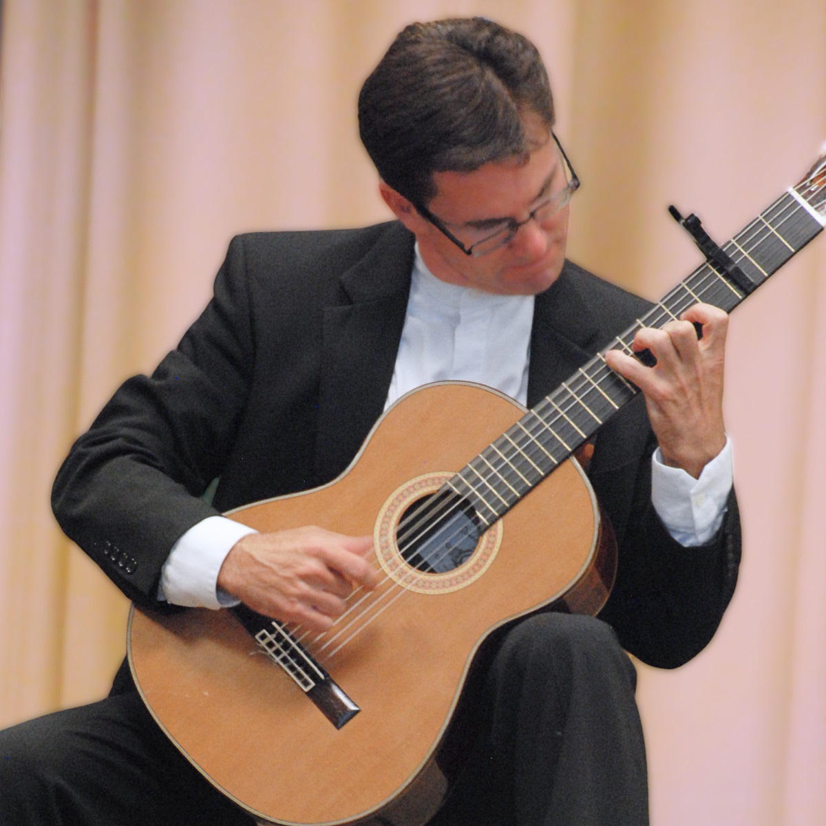 Image depicts musician, Peter Fletcher, playing his classical guitar.