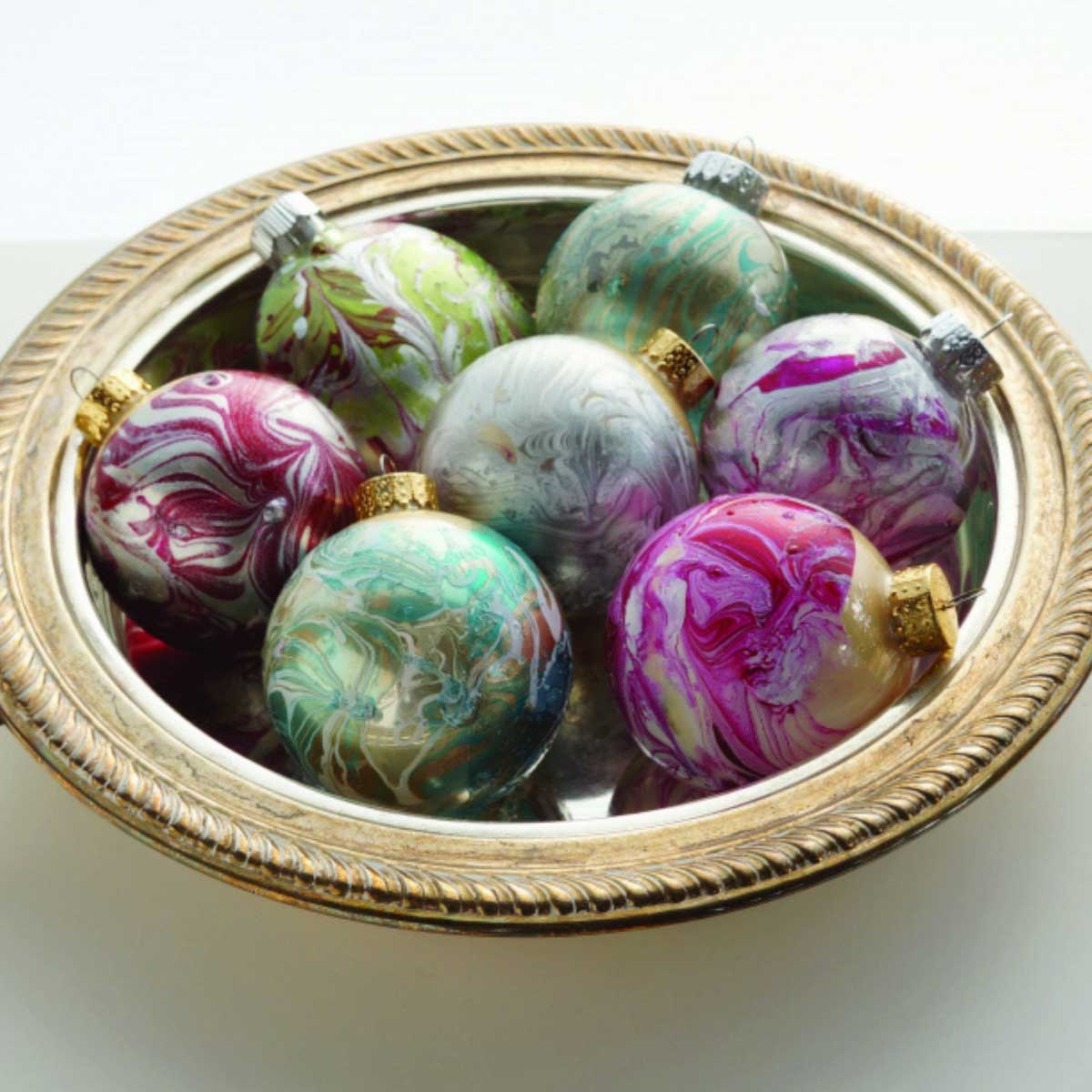Image depicts a bowl of marbled ornaments in a variety of colors.