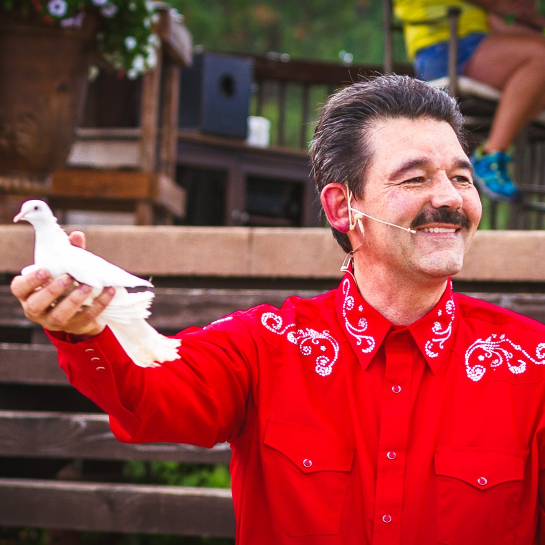 Cecil the Magician holding a dove in his hand as he performs a magic trick.