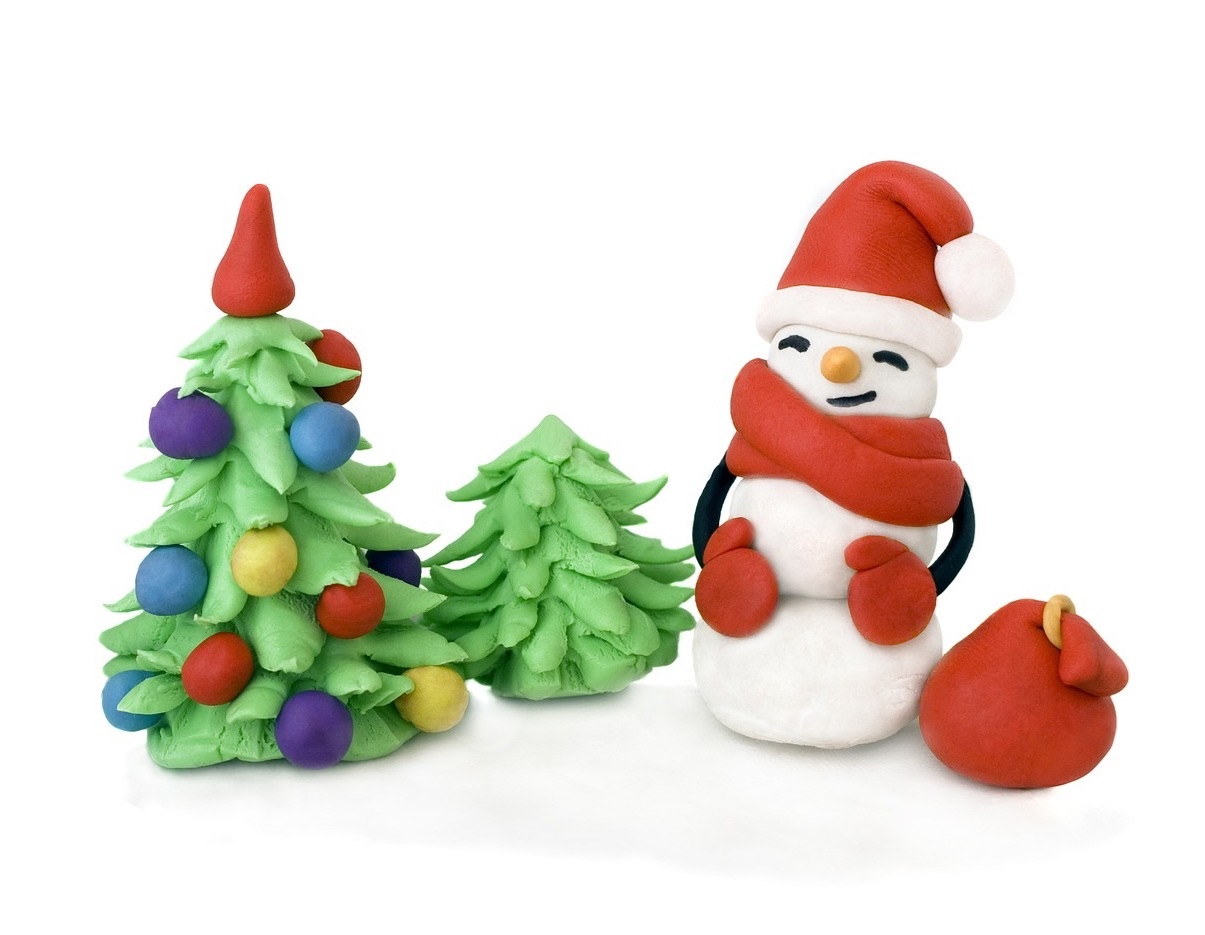 Small snowman wearing a hat next to a tree with colorful lights