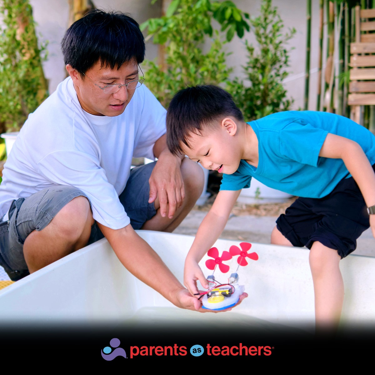 A dad and young kid play together.  At the bottom of the image a logo reads: "Parents as Teachers"