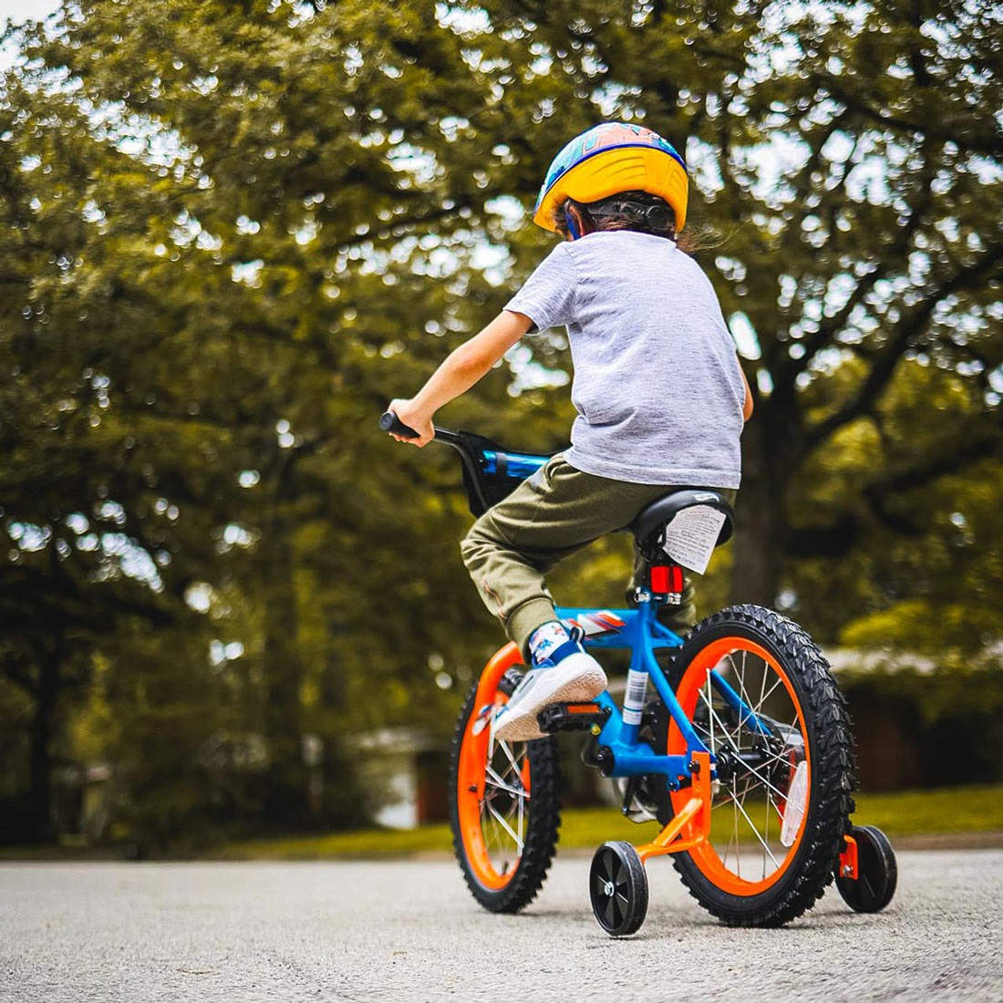 Young boy on his bike with training wheels.