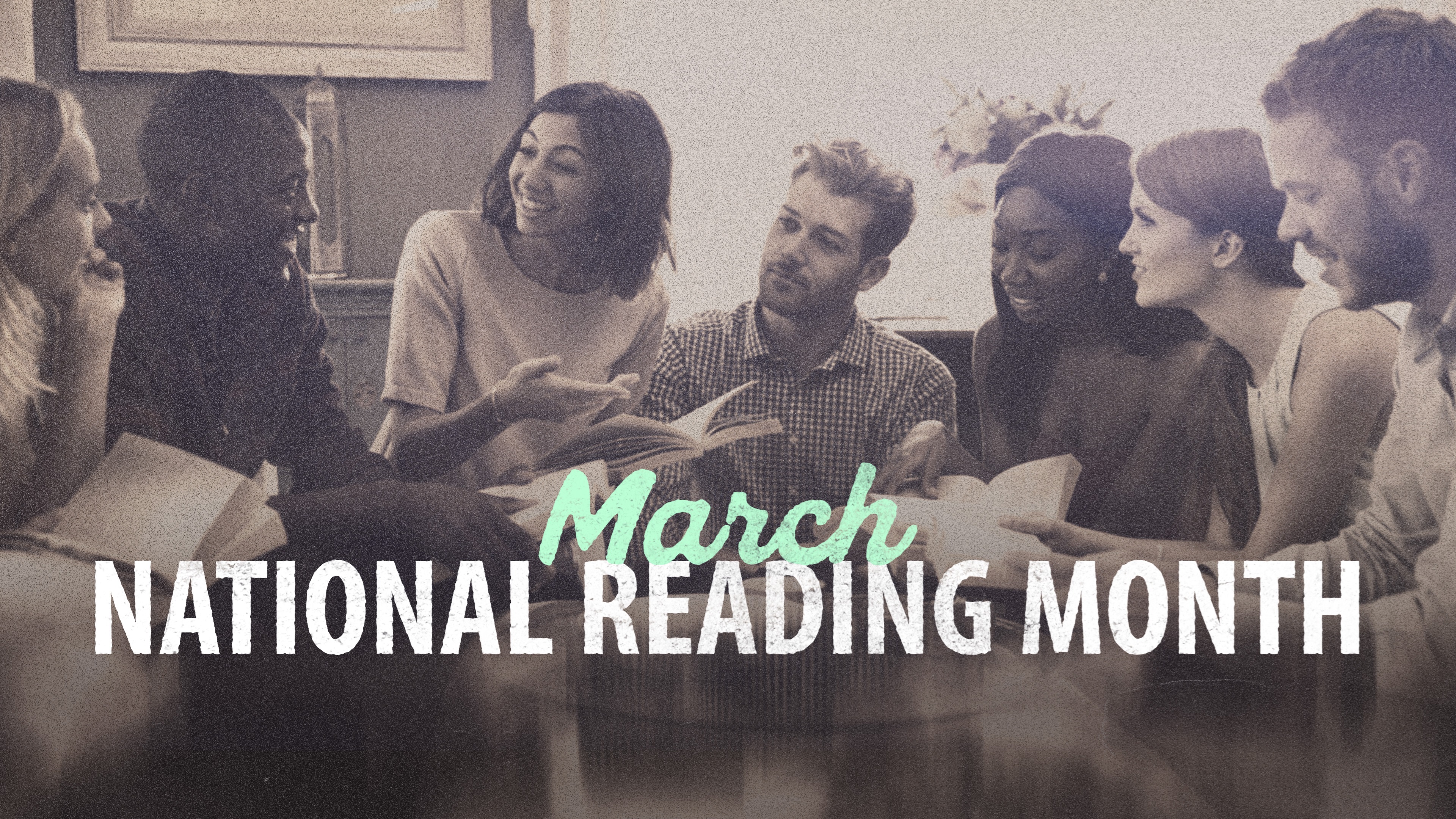 A group of adults smiling and discussing a book. March, National Reading Month.