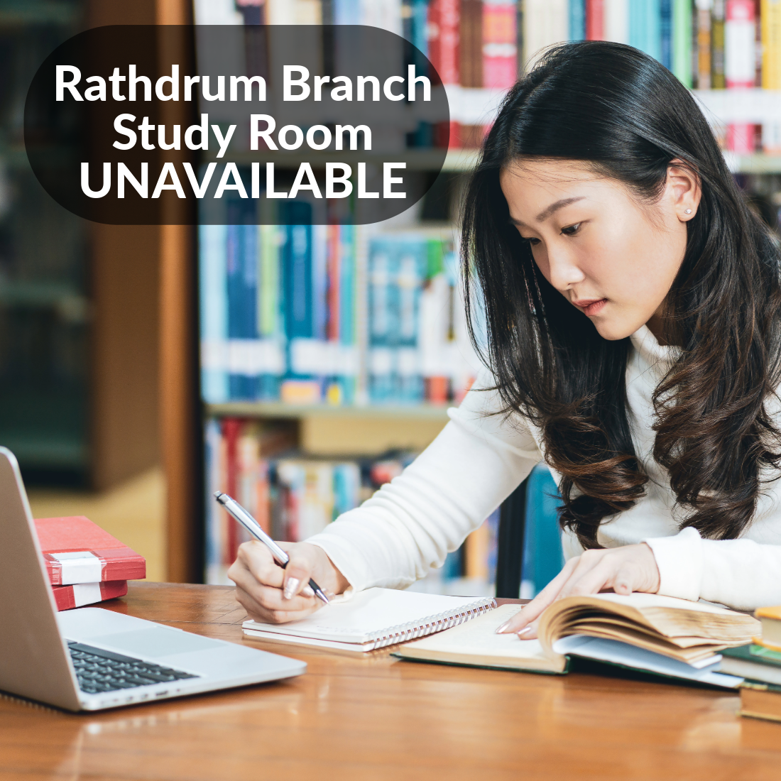 Rathdrum Branch Study Room Unavailable. Woman at a study desk in a library with a computer, and writing in a notebook