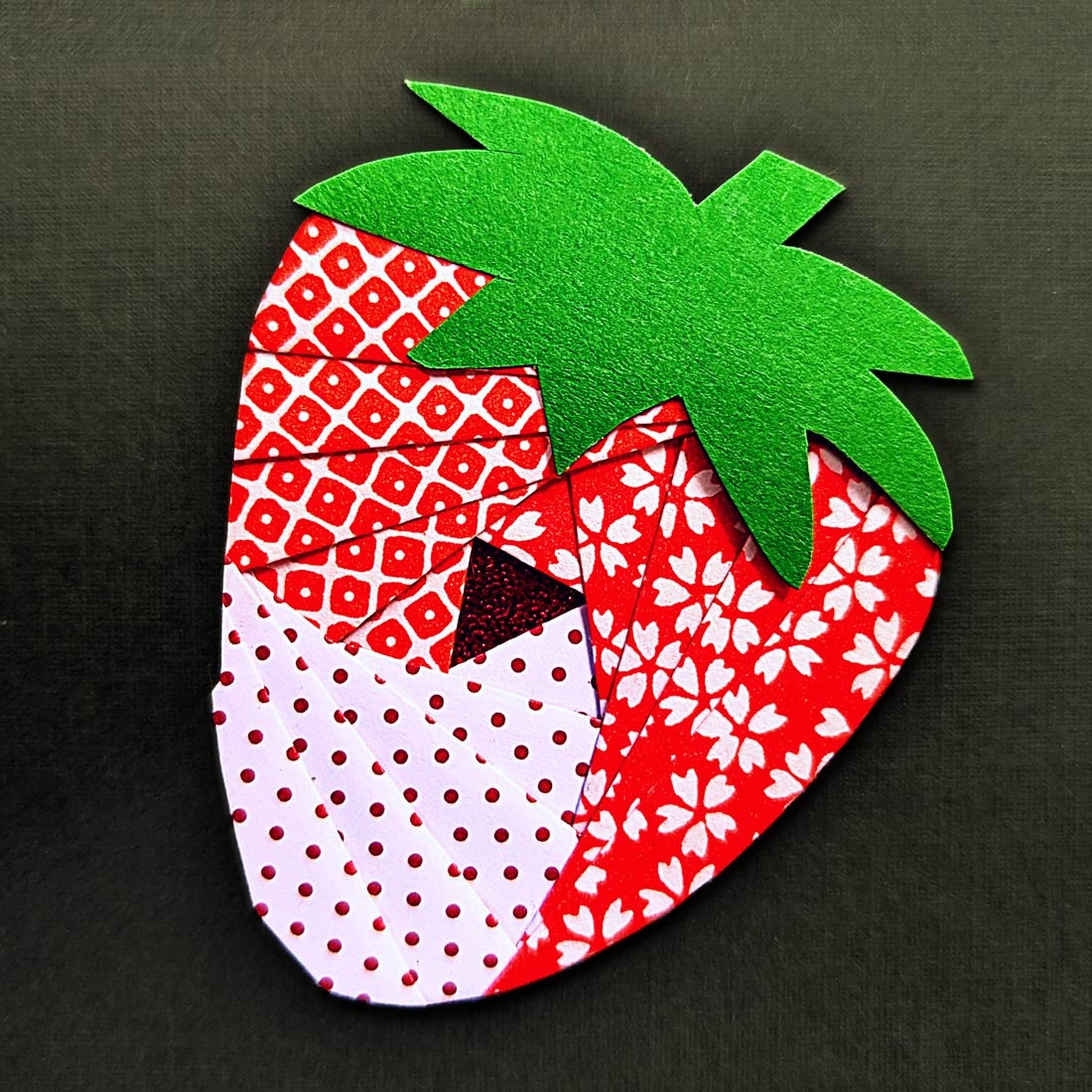 Cute origami craft, a paper folded using the iris style, to make a strawberry.