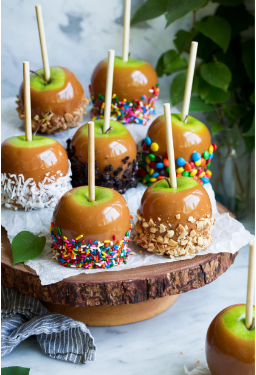 green apples dipped in caramel, with candy, nuts or coconut on the bottom half