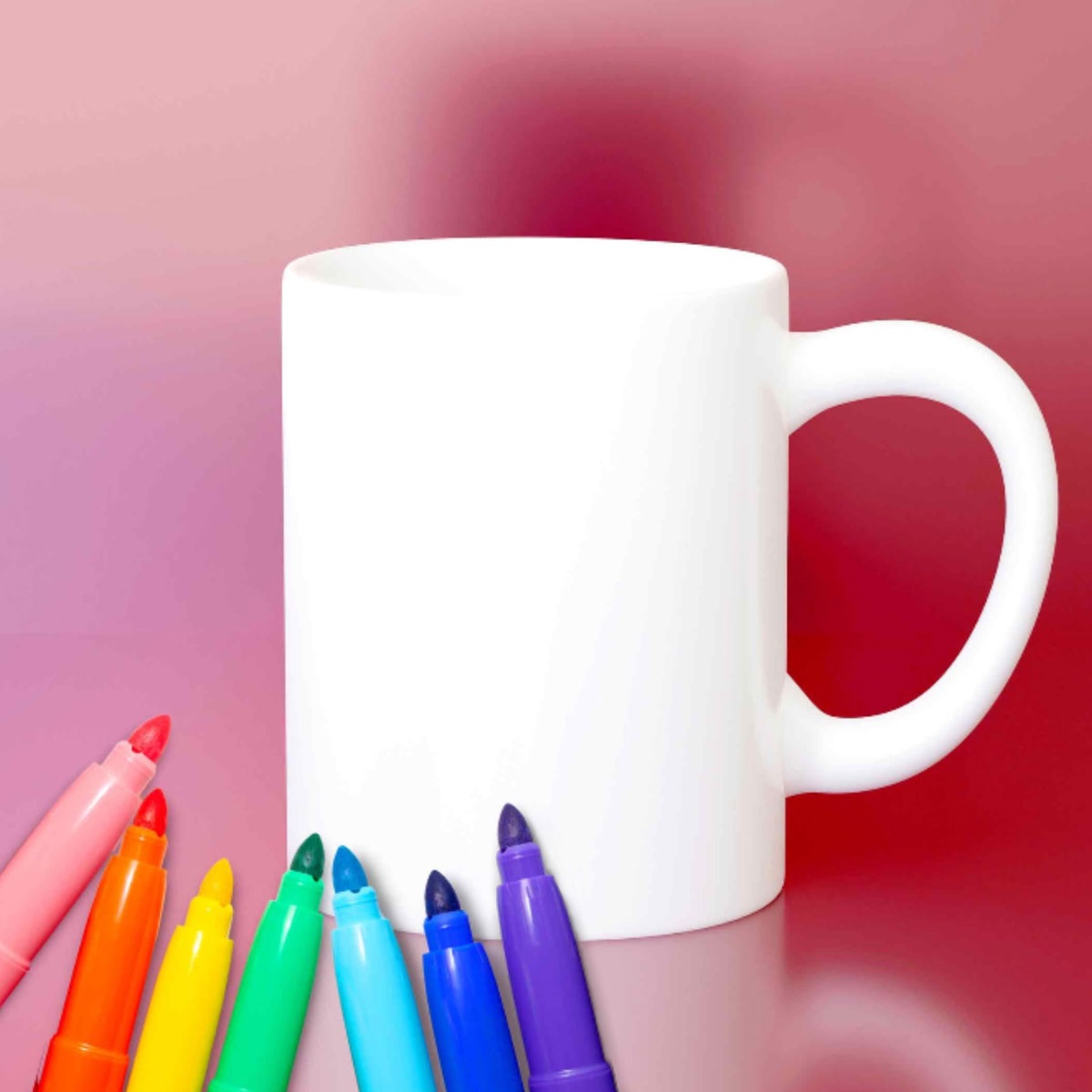 Image depicts a blank white mug and a rainbow of sharpies.