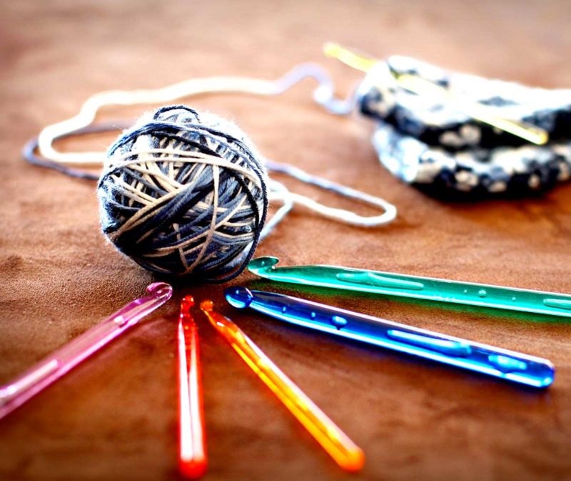Image shows crochet hooks and a ball of yarn.