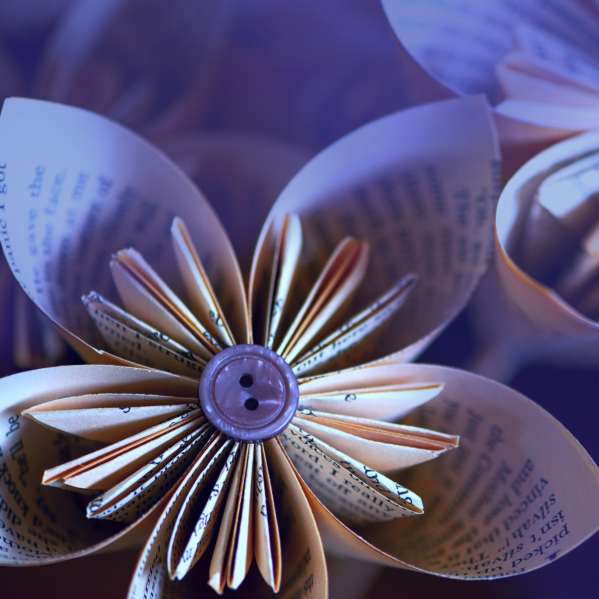 Book pages are folded to look like a flower with a button in the middle.