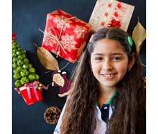 Tween girl smiling with Christmas presents behind her