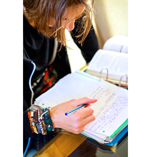 Teen doing homework with a pencil in hand