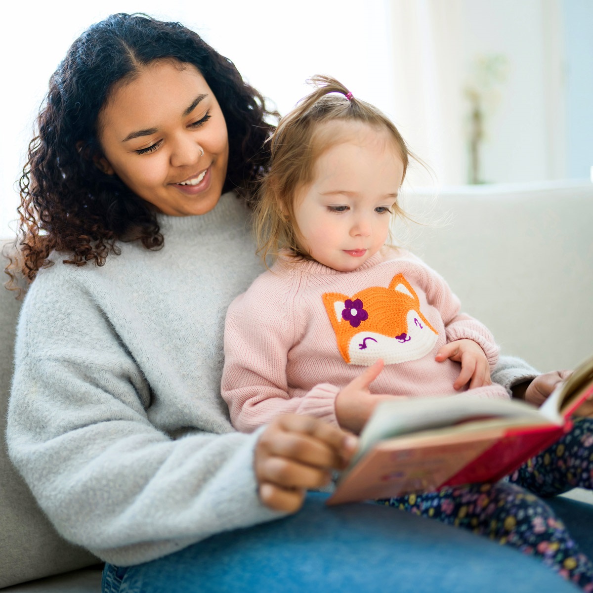 Teen reading to a little girl