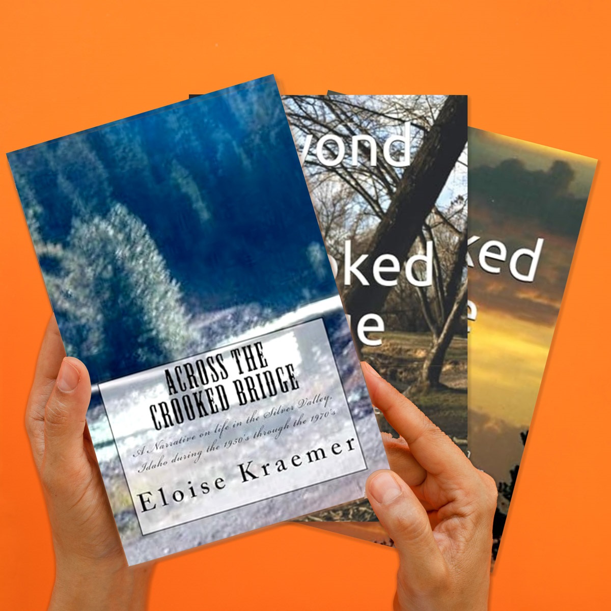 On an orange background hands reach from the bottom of the image holding three of Eloise Kraemer's books.