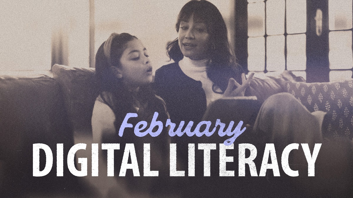 February – Digital Literacy, with a mom teaching her daughter how to use a tablet (mobile device).